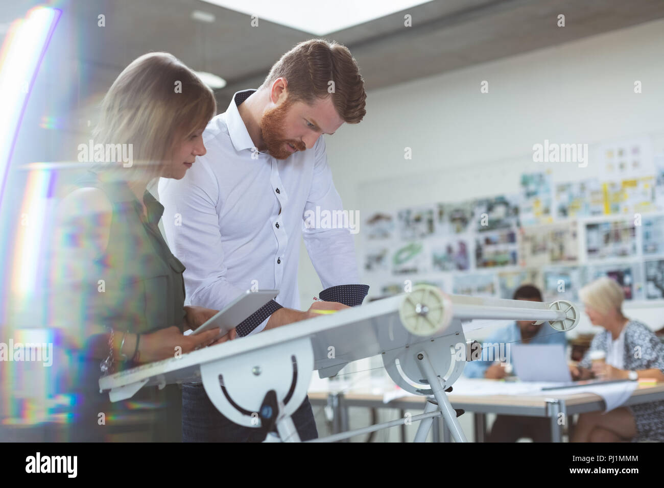 Executives working on drafting table Stock Photo