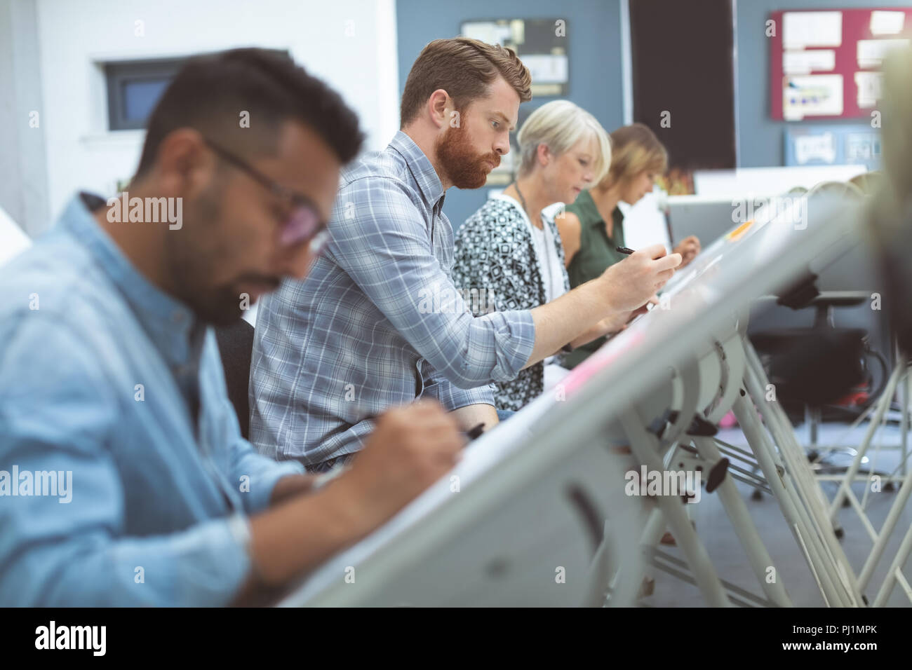 Executives working on drafting table Stock Photo