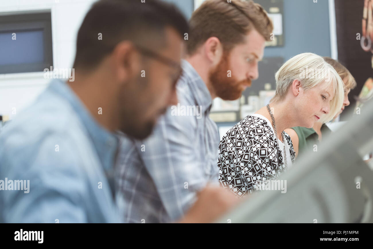Executives working on drafting table in office Stock Photo