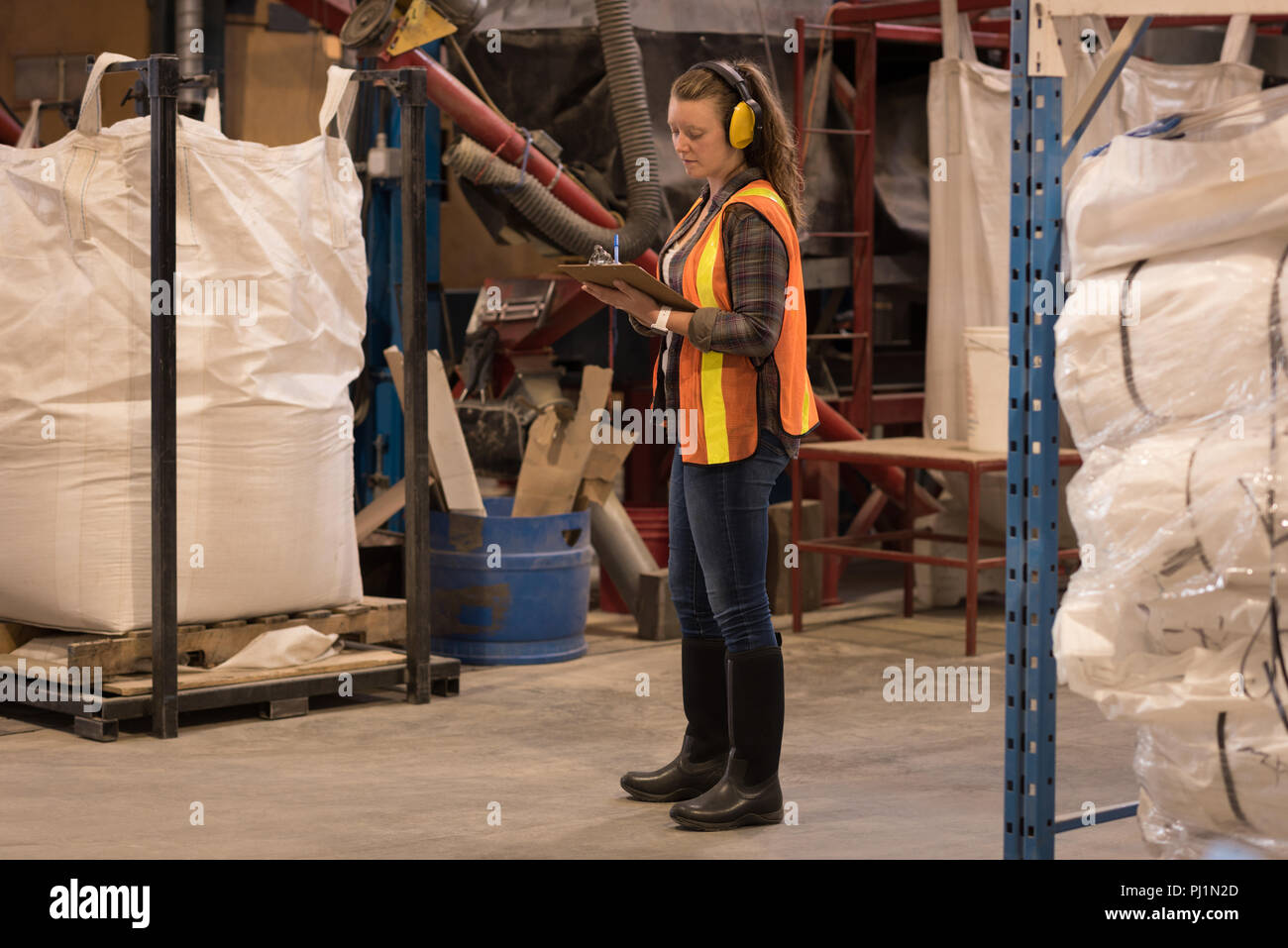 Female worker writing on clipboard Stock Photo