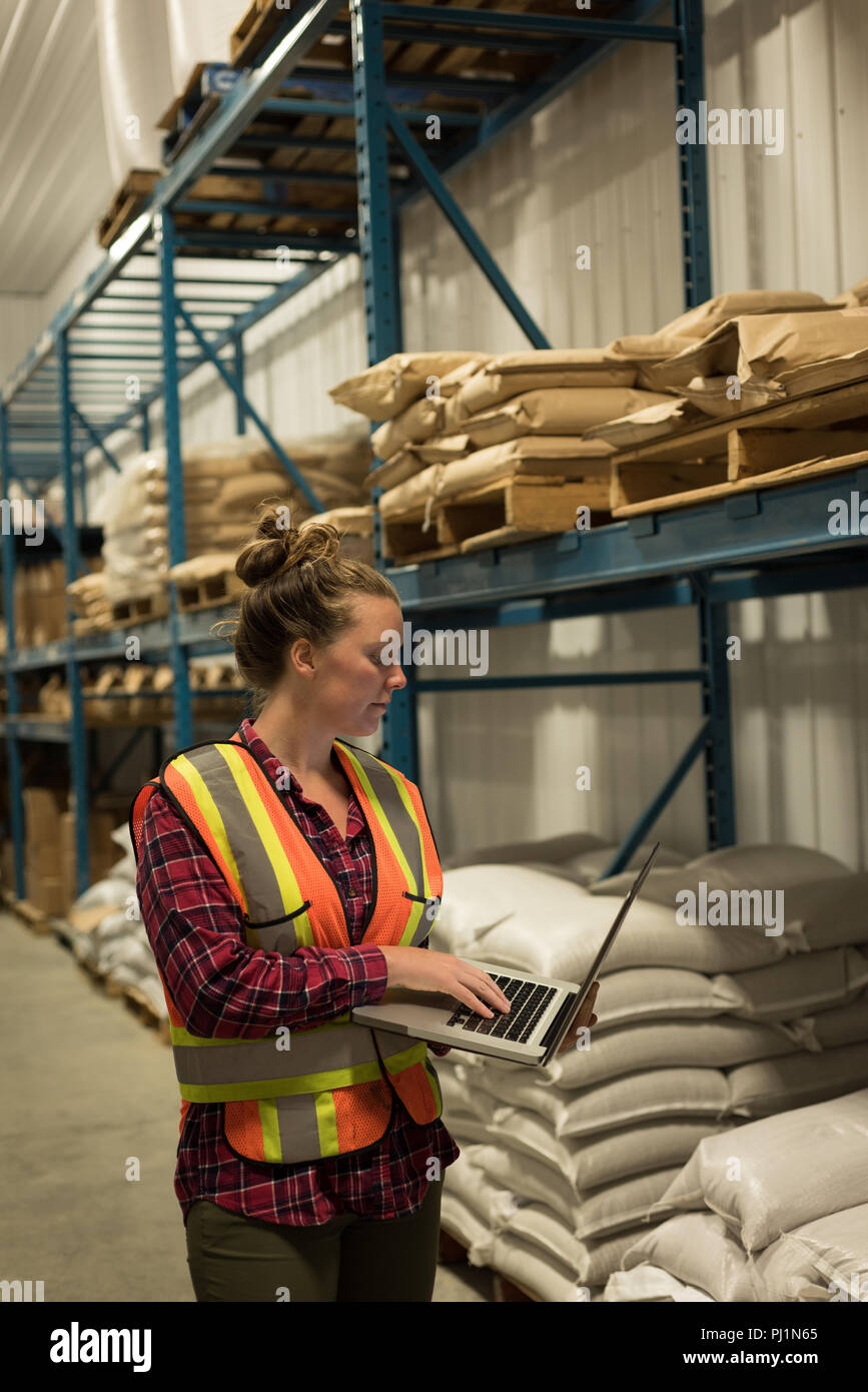 Female worker using laptop at  warehouse Stock Photo