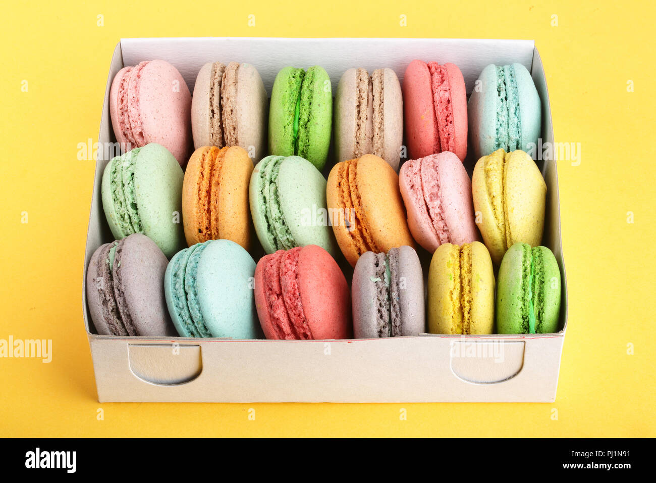 Download Colorful Macarons In Box On Yellow White Background Closeup Stock Photo Alamy PSD Mockup Templates