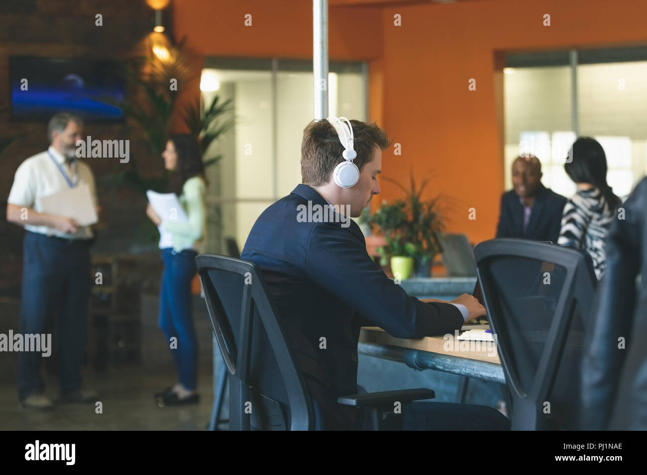 Businessman using laptop at desk Stock Photo