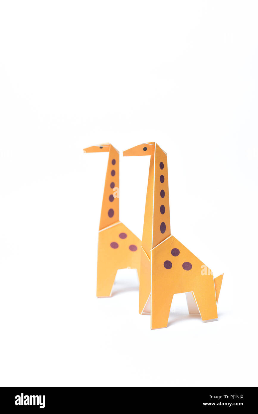 Two origami giraffes stand on a white background Stock Photo