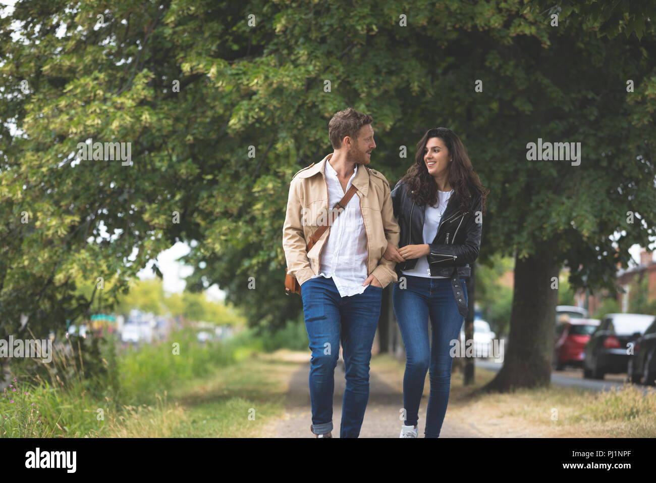 Couple interacting while walking in street Stock Photo
