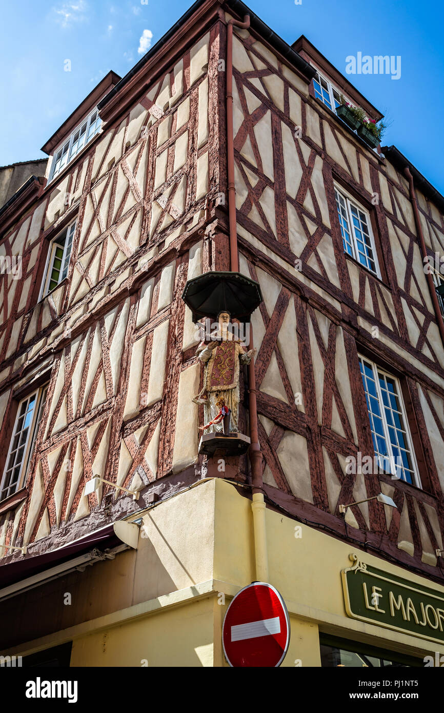 Wooden statue of priest high up on corner of ancient timber framed building in Chalon sur Saone, Burgundy, France on 29 August 2018 Stock Photo