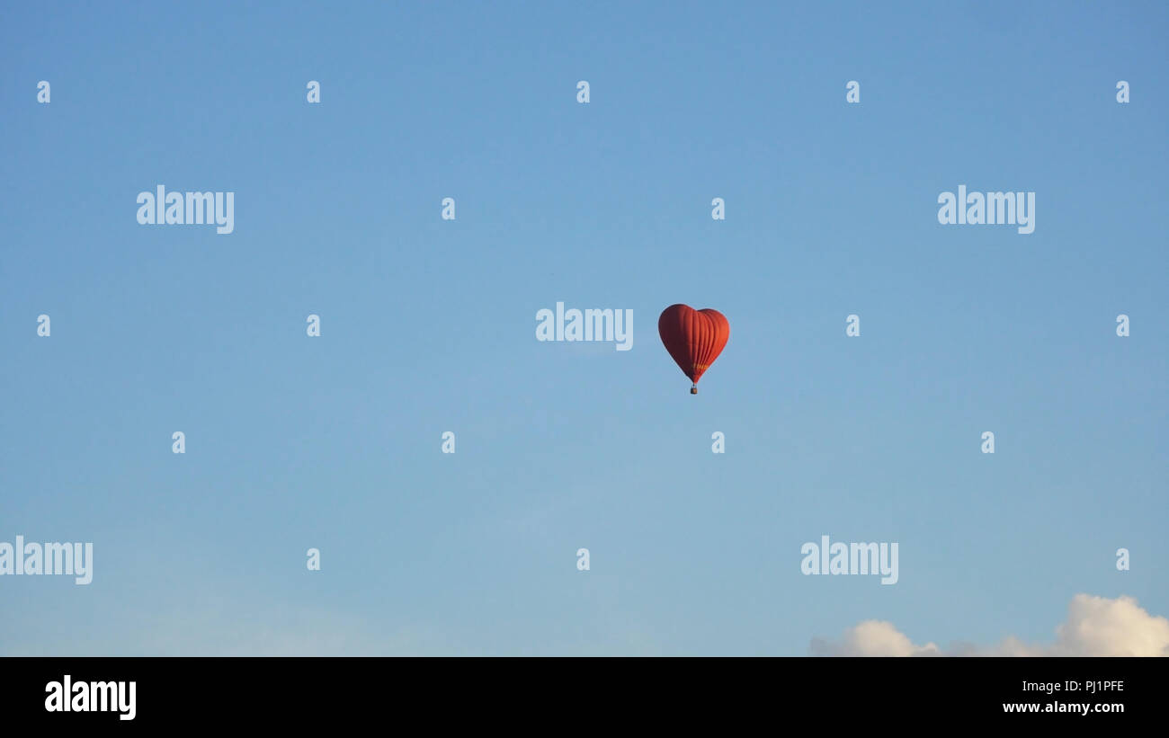 Hot air balloon shape of a heart in the blue sky. Aerostat, Airship ...