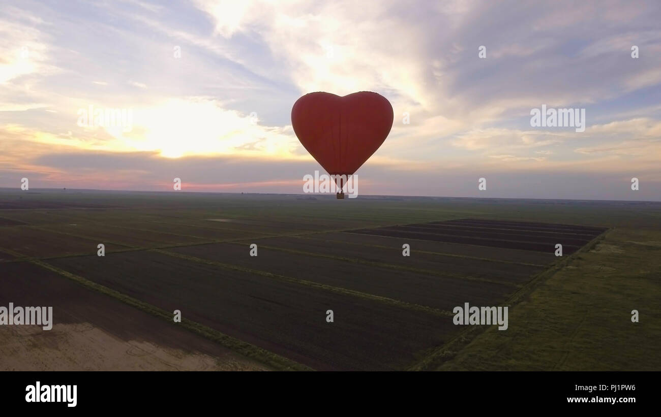 Hot air balloon shape of a heart in the blue sky. Aerostat, Airship ...
