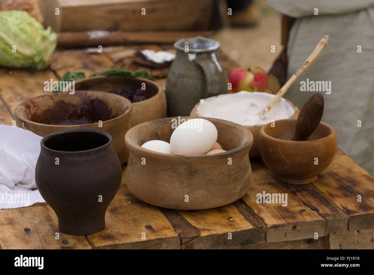 Medieval food preparation including eggs, cream and fruit in wooden bowls or trenchers Stock Photo