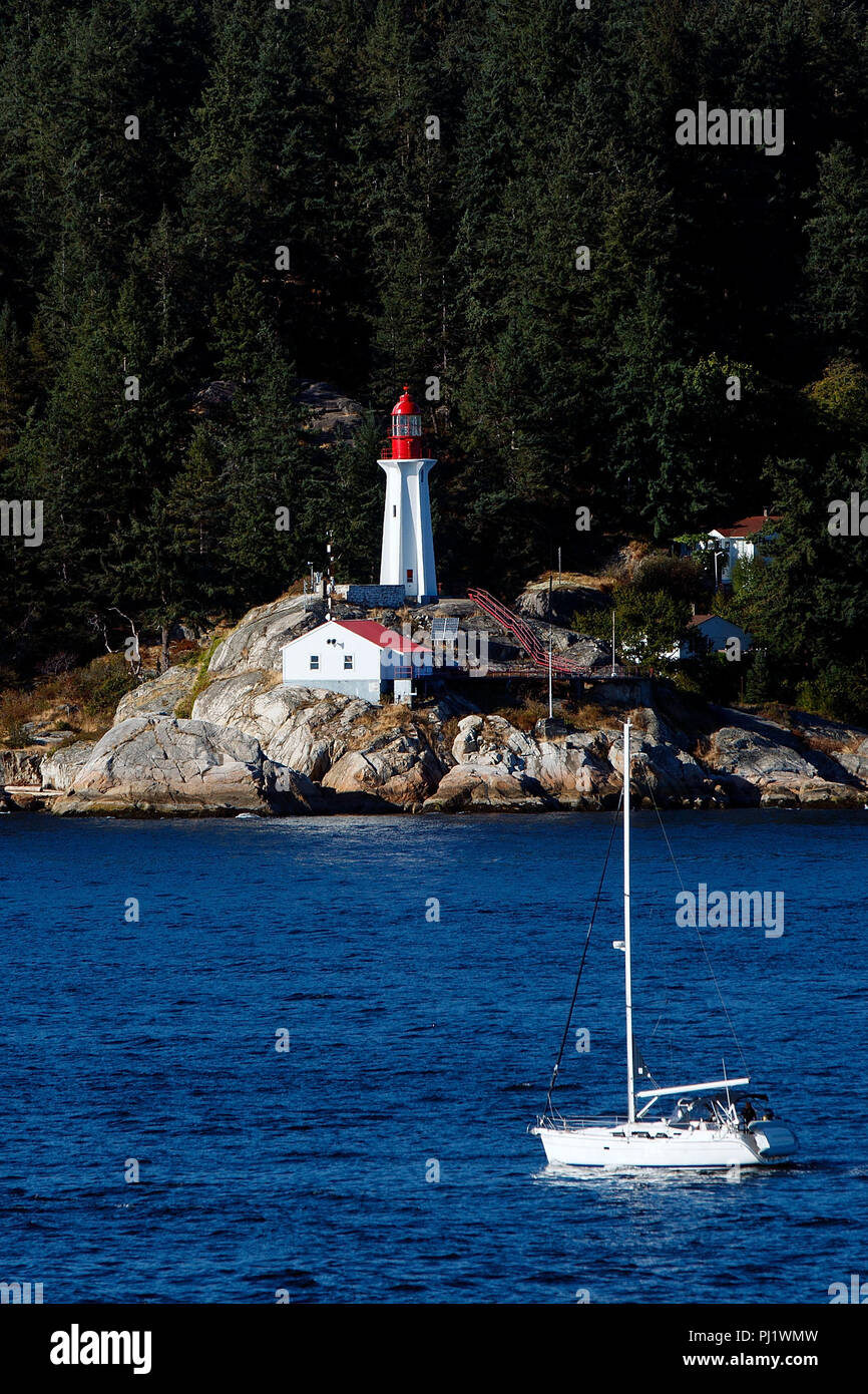Point Atkinson Lighthouse with sailboat passing, West Vancouver, British Columbia, Canada Stock Photo