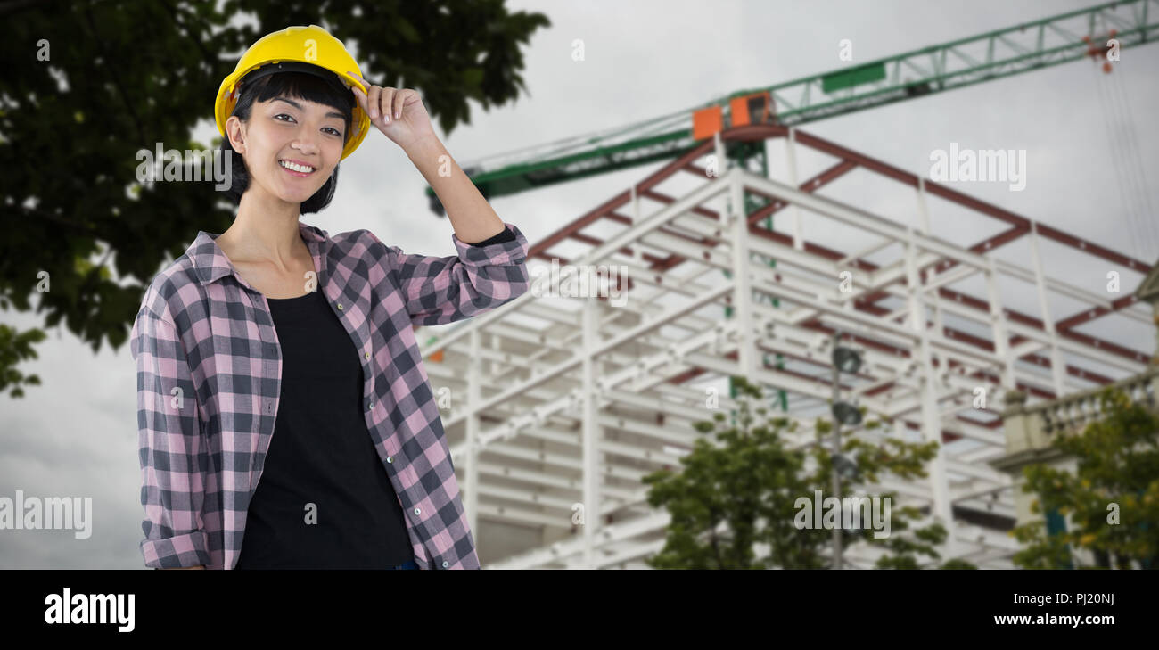 Composite image of female architect in hard hat standing against white background Stock Photo
