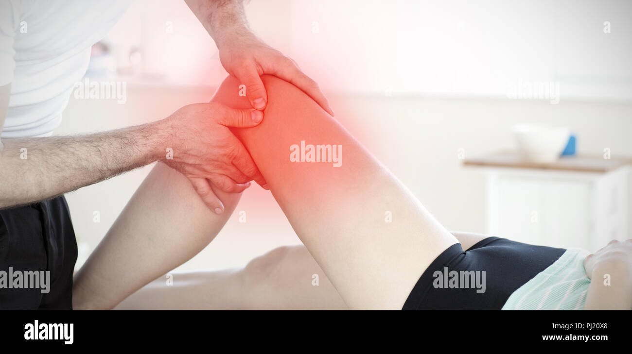 Composite image of handsome young physical therapist giving a leg massage Stock Photo