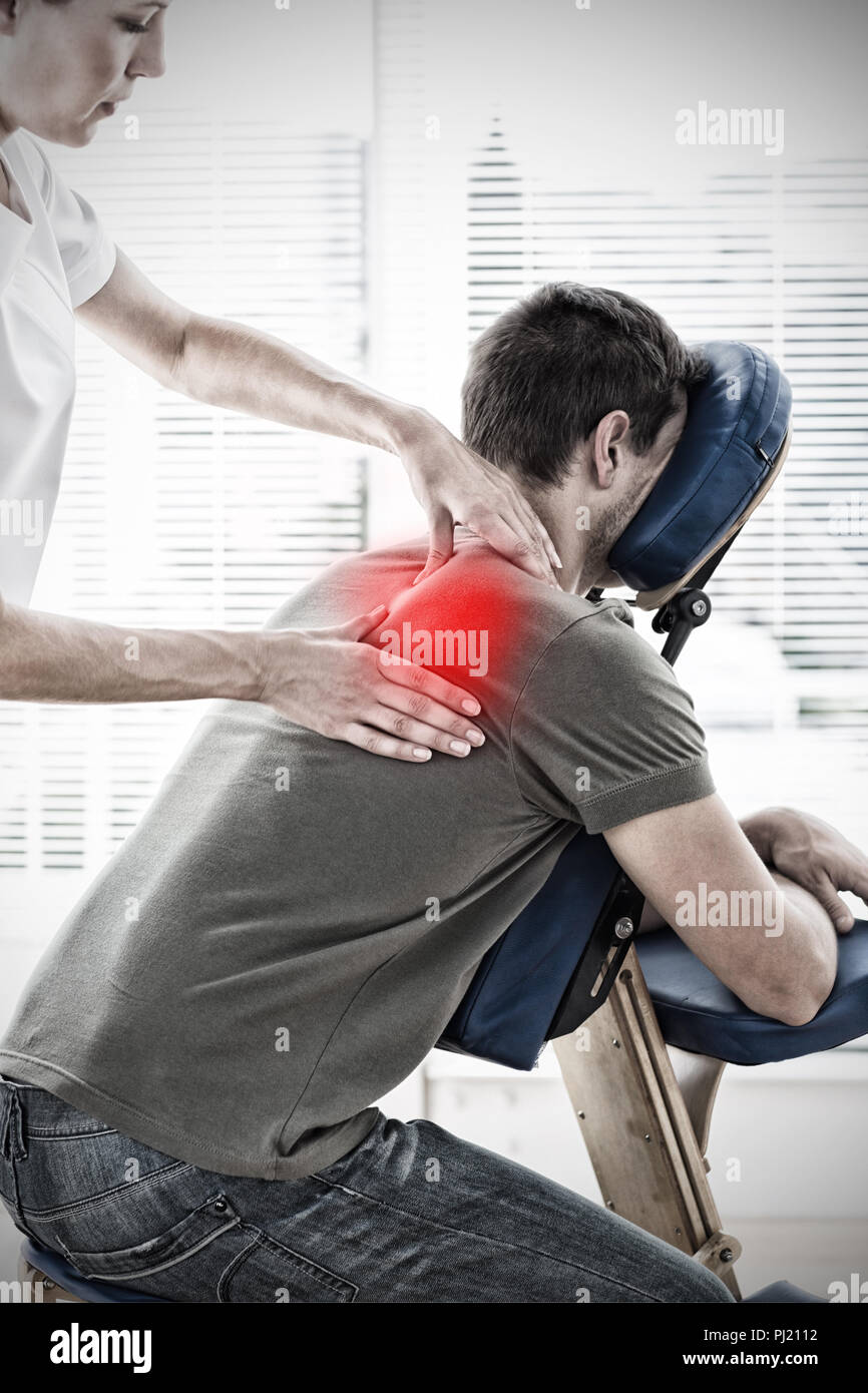 Composite image of therapist massaging in hospital Stock Photo