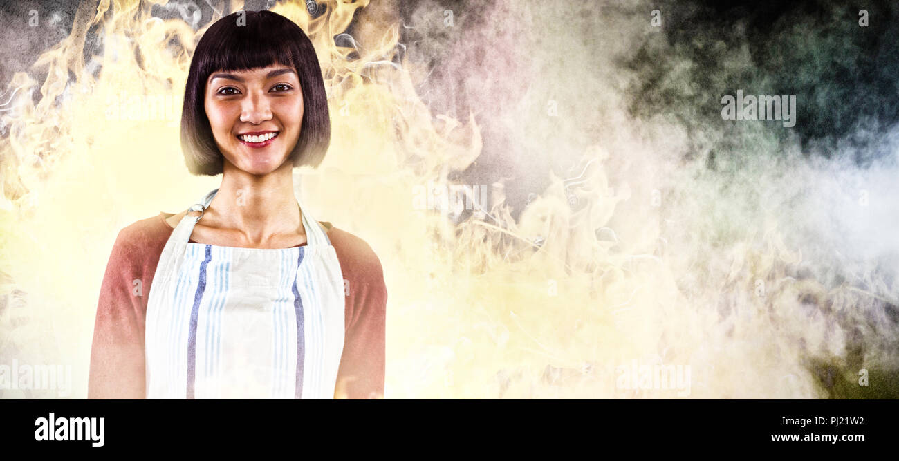 Composite image of smiling waitress in apron standing against white background Stock Photo