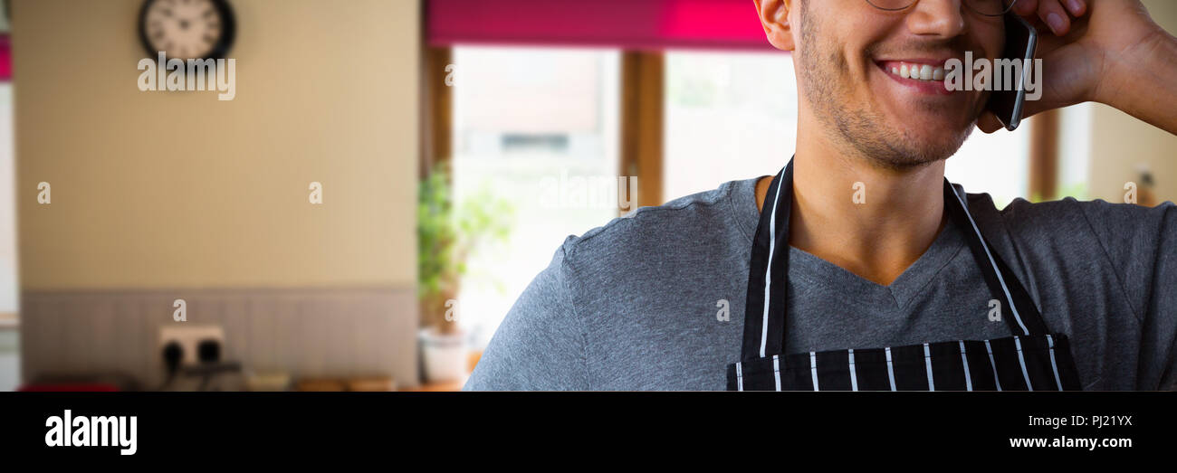 Composite image of male waiter talking on mobile phone Stock Photo