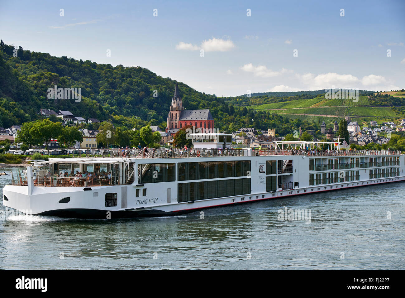 Passenger cruise ship Viking Modi passing Oberwesel on the river Rhine, with Church of our Lady (Liebfrauenkirche), gothic style Catholic Church in th Stock Photo
