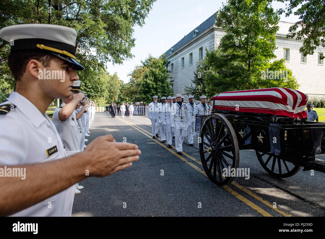 Midshipmen salute as the flag draped casket of Sen. John McCain as a horse-drawn caisson processes to the United States Naval Academy Cemetery for his burial service September 2, 2018 in Annapolis, Maryland. John S. McCain, III graduated from the United States Naval Academy in 1958. He was a pilot in the United States Navy, a prisoner of war in Vietnam, a Congressmen and Senator and twice presidential candidate. He received numerous awards, including the Silver Star, Legion of Merit, Purple Heart, and Distinguished Flying Cross. Stock Photo