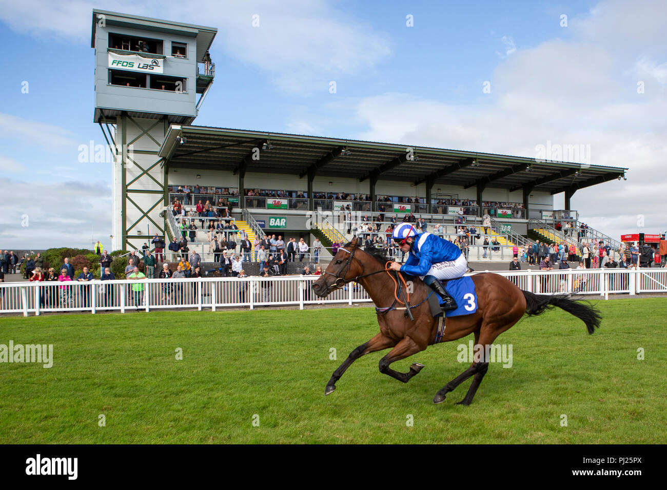 Racehorse Wufud ridden by jockey Dane O'Neill on the way to winning a race at Ffos Las Stock Photo