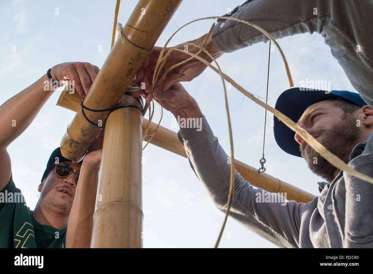 04.09.2018, Saxony-Anhalt, Magdeburg: Manfred Gramer (l) and Stepahn Murer  of the "Kulturanker" association fix the bamboo poles on a pavilion under  construction in the Elbauenpark. A larger edition of the bamboo building,