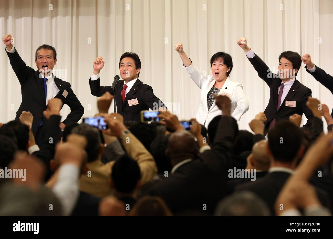 Tokyo, Japan. 4th Sep, 2018. Japan's second largest opposition Democratic Party for the People new president Yuichiro Tamaki (2nd L) and and another candidate Keisuke Tsumura (L) raise their fists in the air after Tamaki was elected at the party convention in Tokyo on Tuesday, September 4, 2018. The Democratic Party for the People was formed in May as merger of Democratic Party of Japan and Party of Hope. Credit: Yoshio Tsunoda/AFLO/Alamy Live News Stock Photo