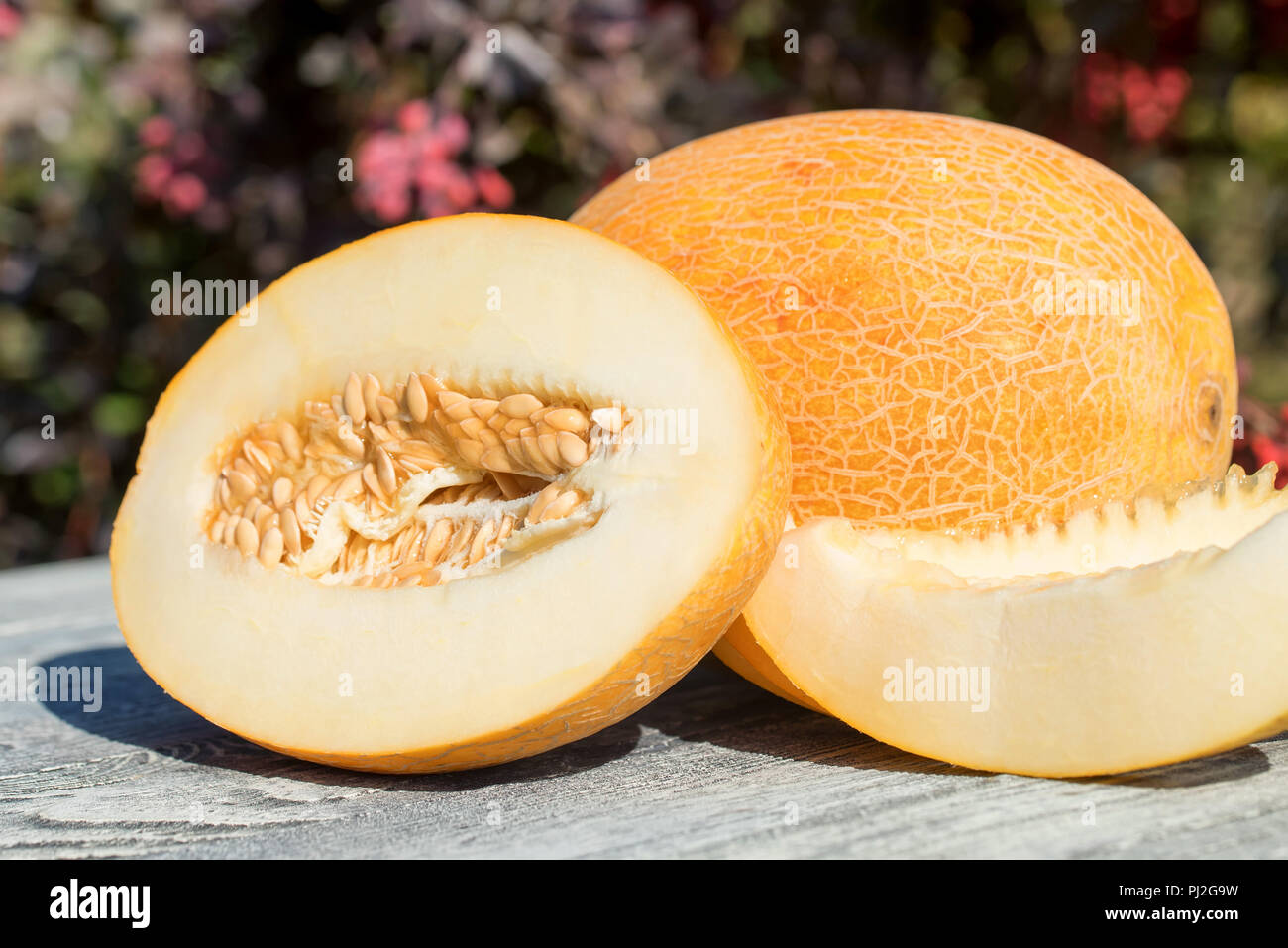 Whole and sliced melon on wooden table outdoors Stock Photo