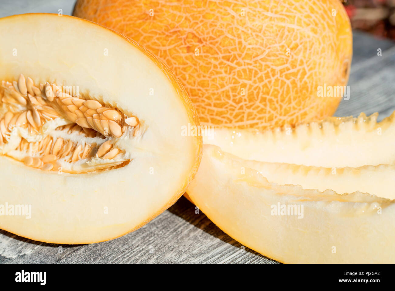 Whole and sliced melon on wooden table outdoors Stock Photo