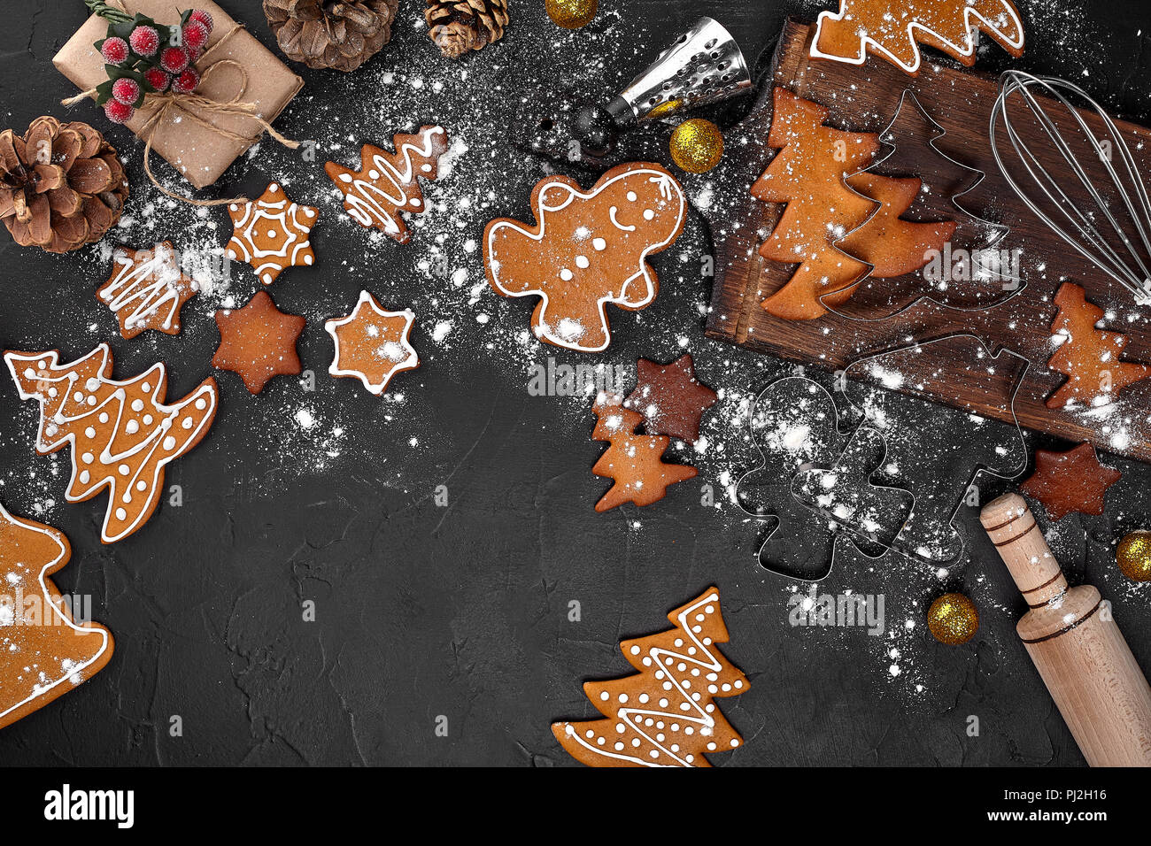 Flour New Year background. Christmas tree branches, gingerbread cookies,  spices and baking supplies on black wood background. Christmas, New Year  gree Stock Photo - Alamy