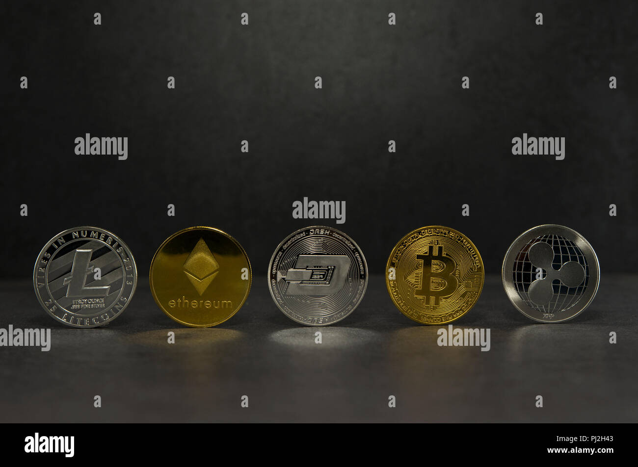a litecoin and ethereum and dash and bitcoin and ripple together for a black background ,Coins of the four crypto currencies with the highest market capitalization  Stock Photo