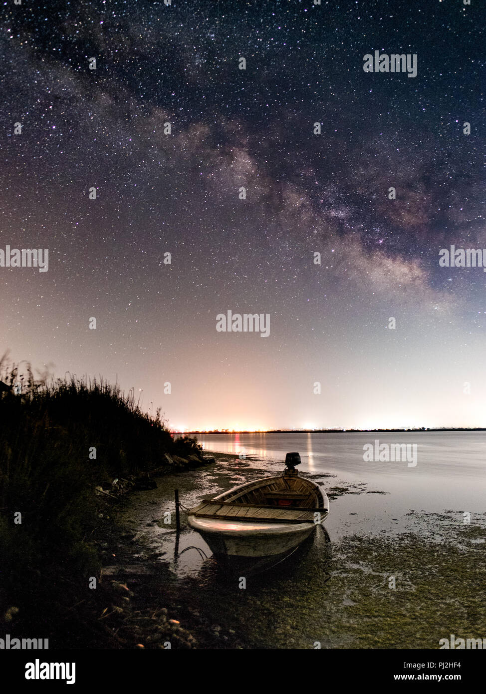 night landscape photography. lake boat and milky way Stock Photo