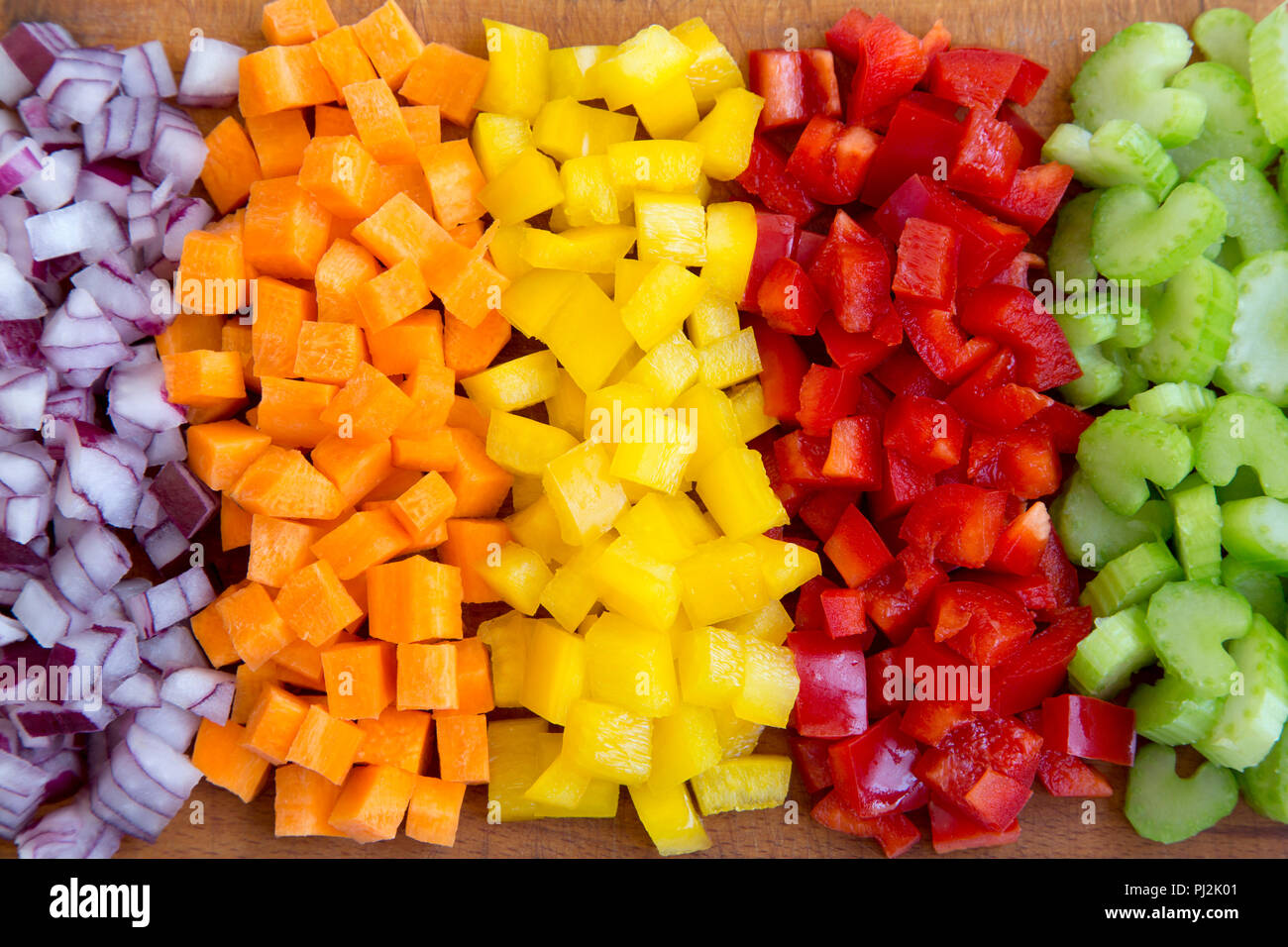 https://c8.alamy.com/comp/PJ2K01/chopped-fresh-vegetables-carrot-celery-red-onion-peppers-arranged-on-cutting-board-overhead-view-close-up-PJ2K01.jpg