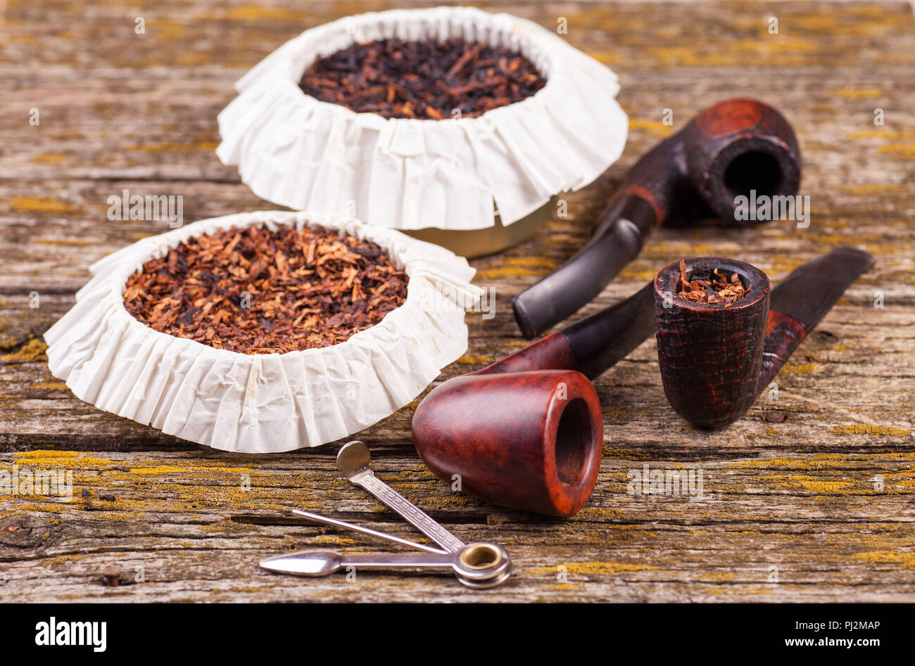 Vintage smoking pipes. Good expensive tobacco. Background of old boards  Stock Photo