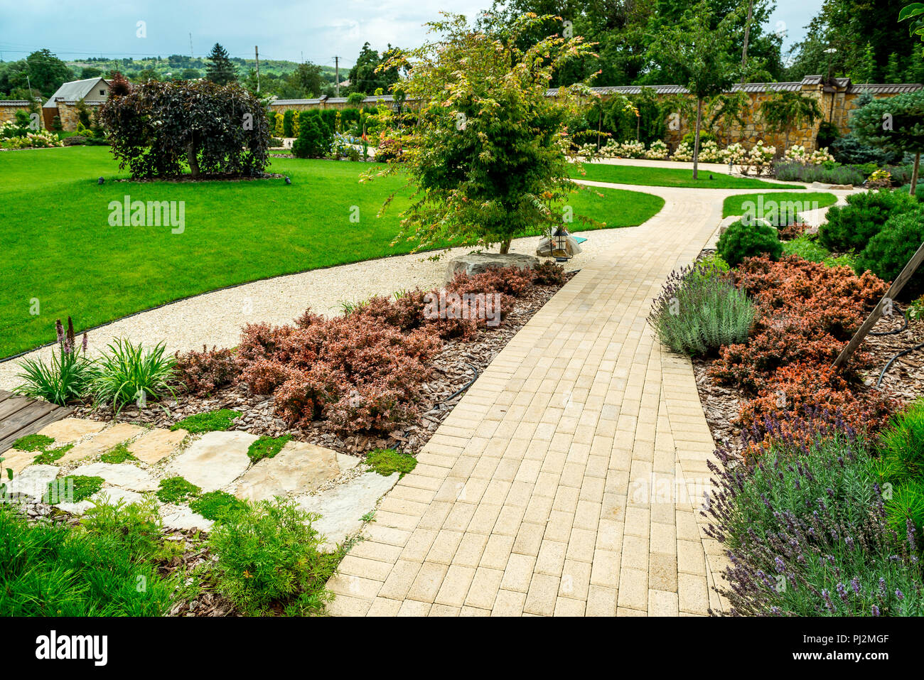 A country house with a beautiful backyard behind the house, landscape design Stock Photo