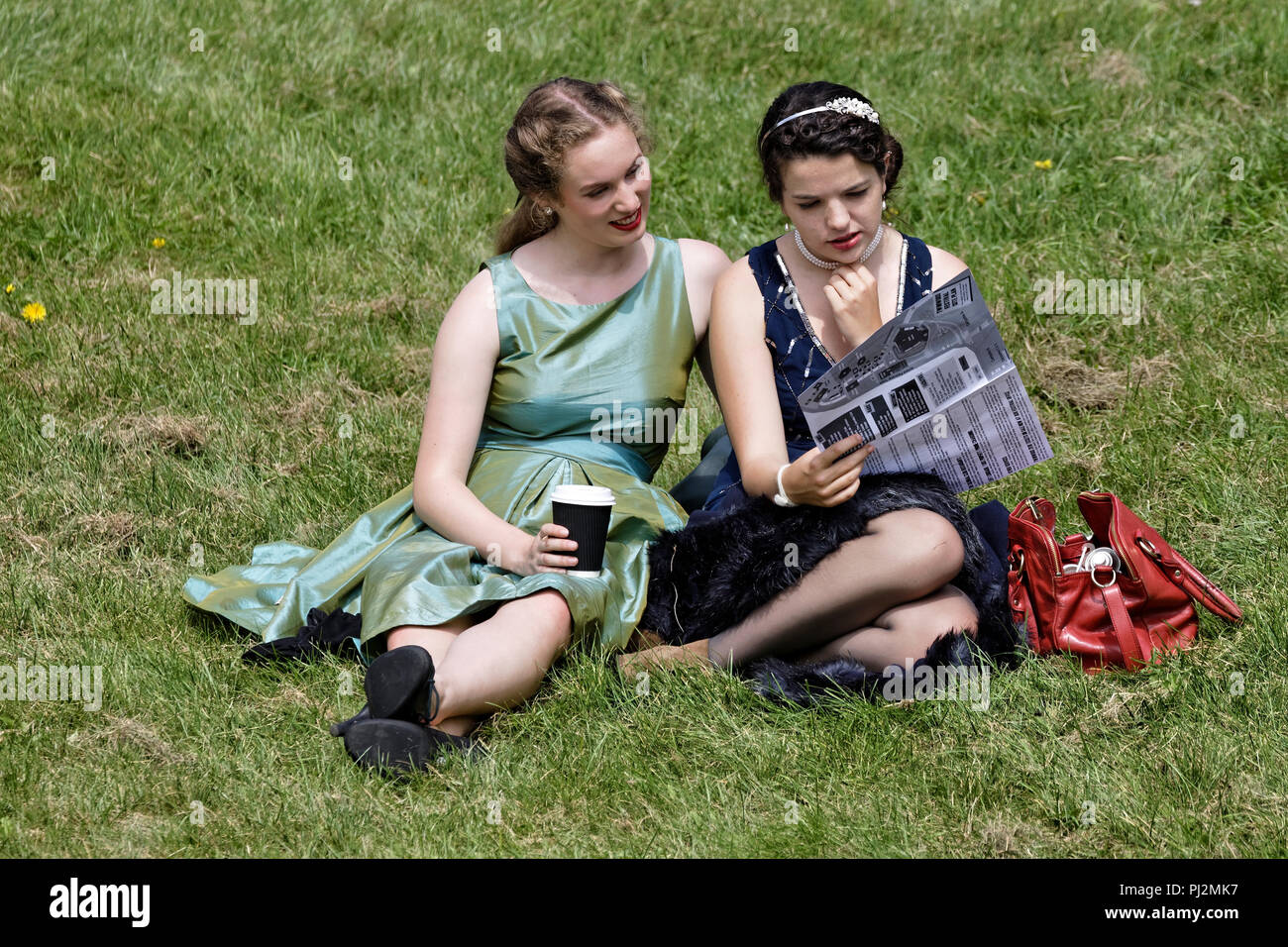 Two young women peruse a festival programme Stock Photo