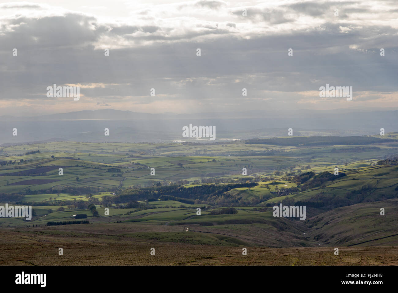 Cumbrian Landscape, Eden Valley, and distant Lake District hills taken from Hartside Top near Alston in the Pennines with sun rays breaking through Stock Photo