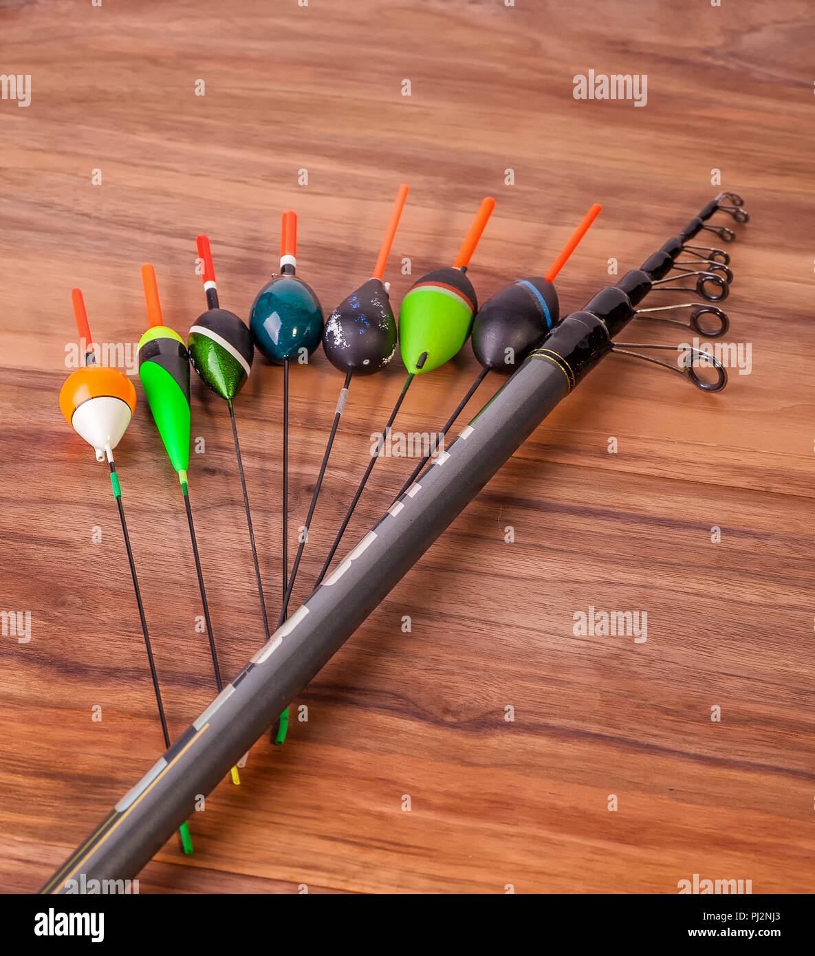 fishing pole with rings and reel, floats lie on American walnut boards  Stock Photo - Alamy