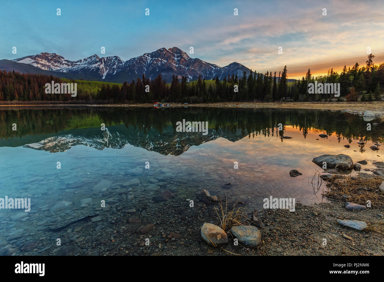 Before sunrise the Pyramid Mountains in Patricia Lake (Jasper National Park / Canada) are reflected. Stock Photo