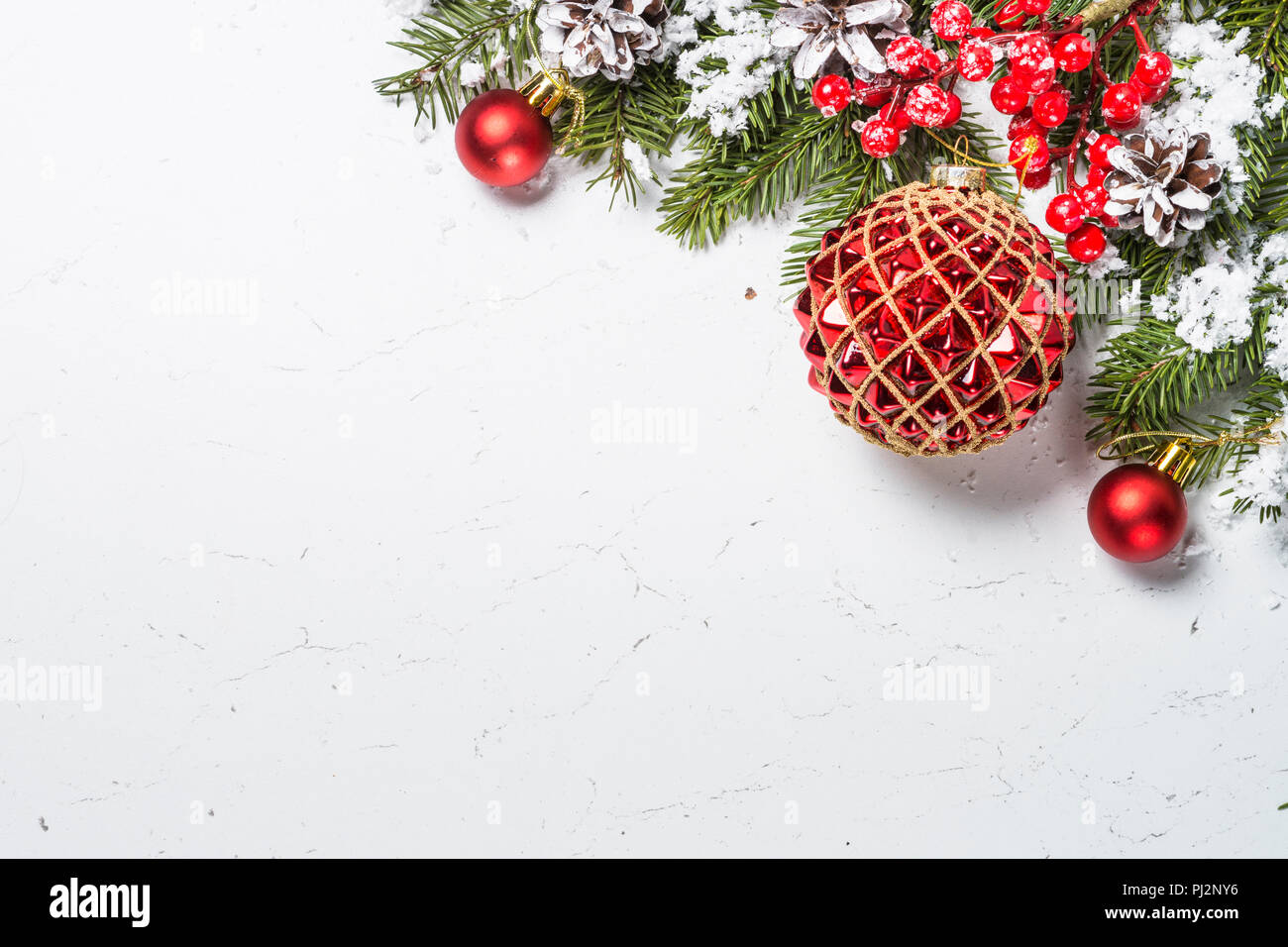 Christmas background. Red christmas decorations with snow and fir tree  branch on white marble table. Top view with copy space Stock Photo - Alamy
