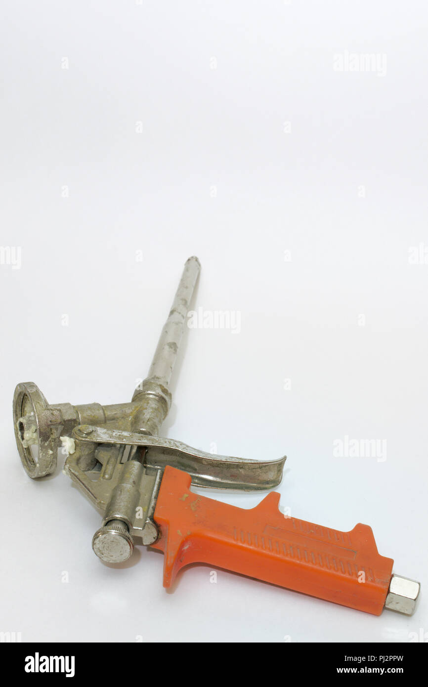 used mounting foam gun with orange plastic handle Stock Photo