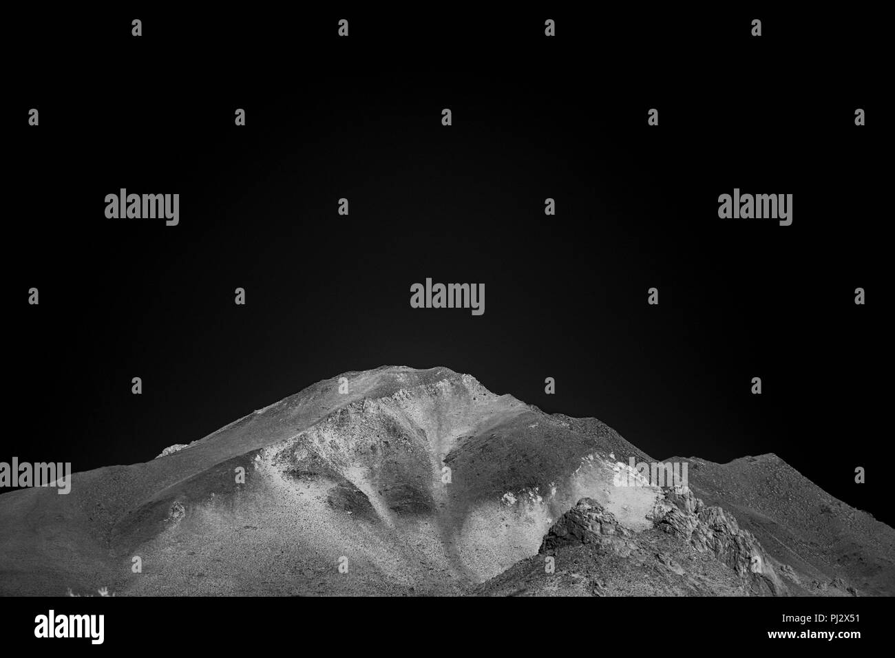 Tall barren mountain Peake under a black night sky. Stock Photo