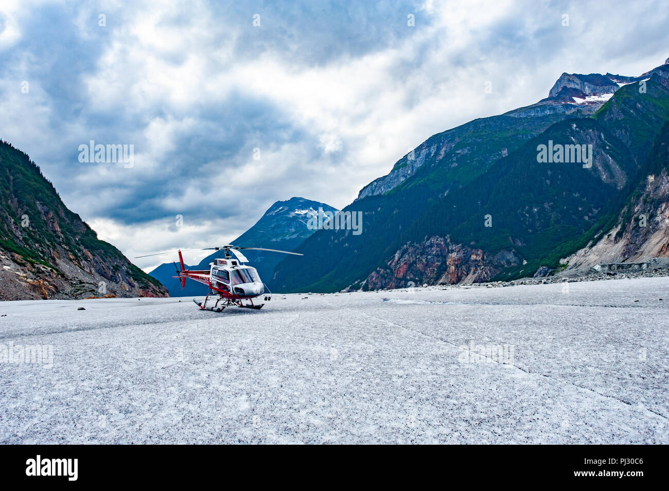 Glacier helicopter tour - Juneau Alaska - a helicopter lands on a glacier during a cruise ship excursion over the Juneau icefield to Gilkey Glacier Stock Photo