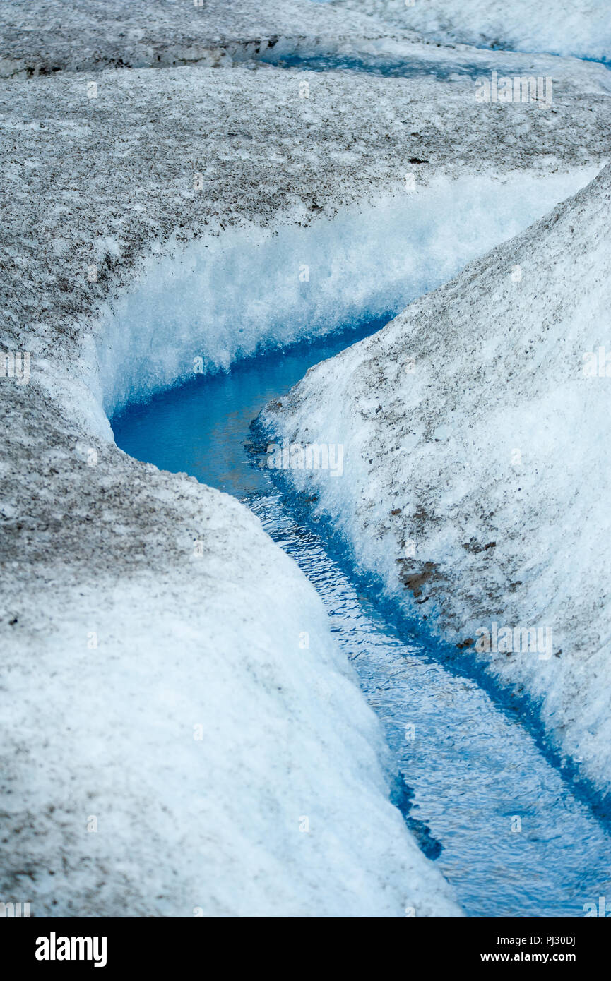 Glacier helicopter tour - Juneau Alaska - cruise ship excursion over the Juneau icefield landing on Gilkey Glacier - stunning blue glacial meltwater Stock Photo
