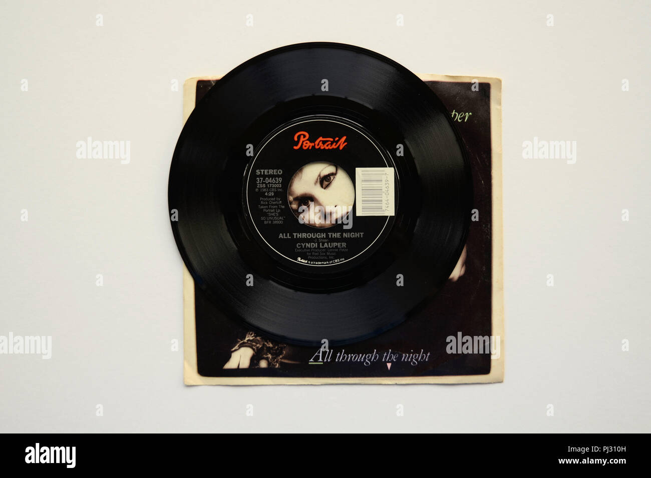 Sleeve and 45 RPM vinyl record of Cyndi Lauper's song 'All Through The Night' released in 1983 by Portrait Records. Stock Photo