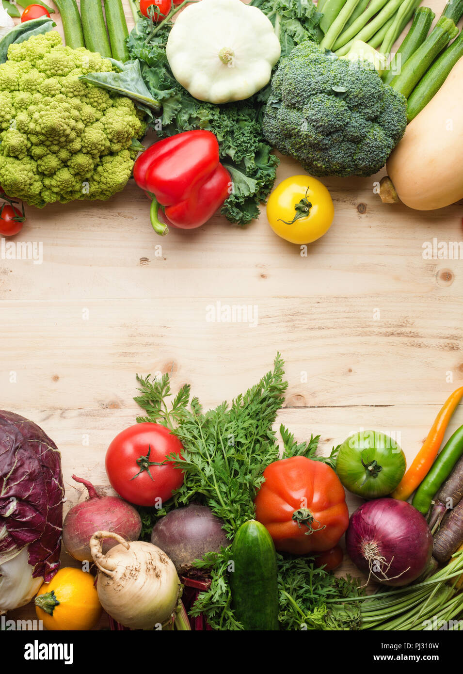 Fresh farm produce, organic vegetables and herbs on pine wooden table, healthy background, copy space for text in the middle, vertical, top view, selective focus Stock Photo