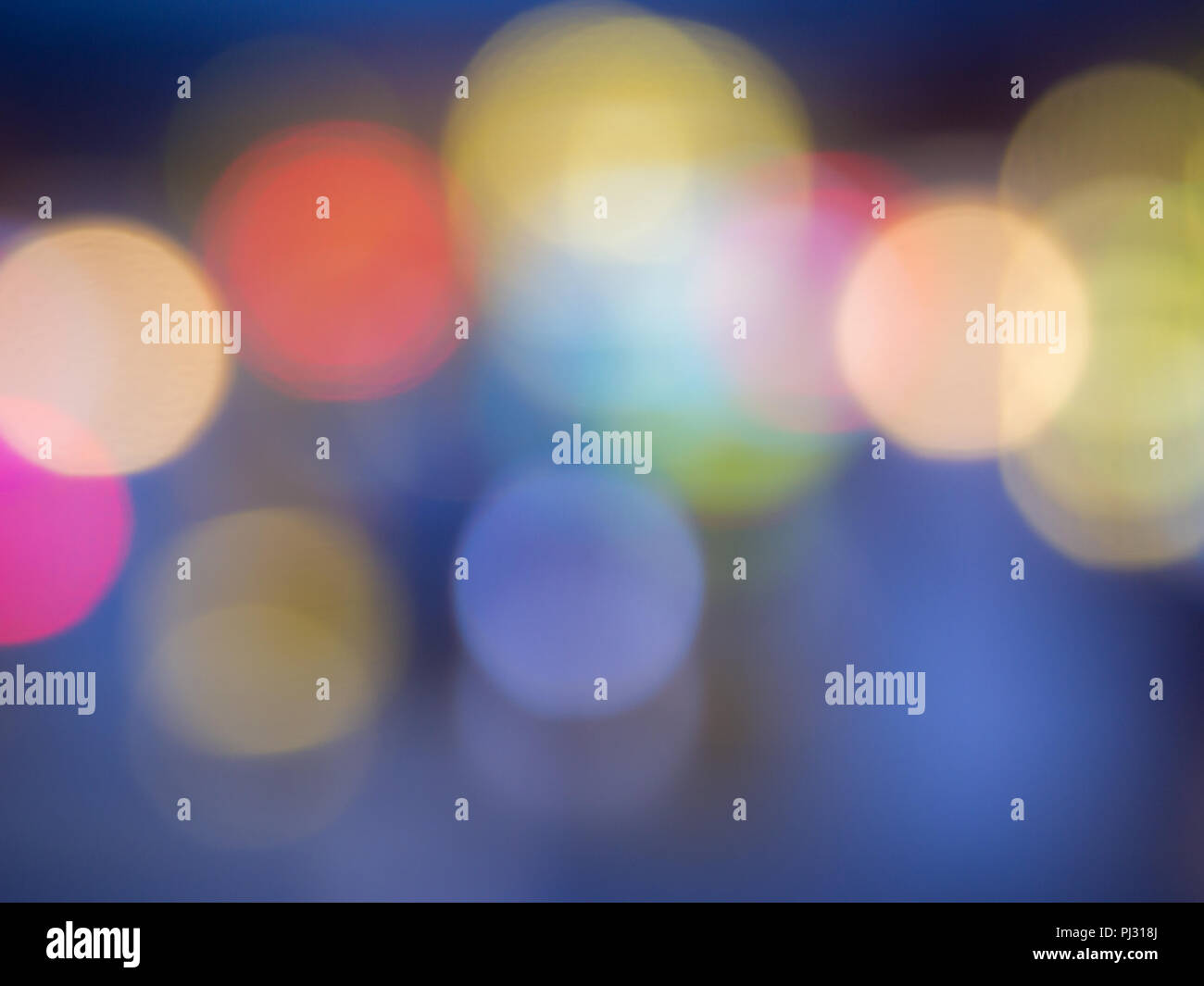 Background formed by blurred reflections of colored lights. Stock Photo