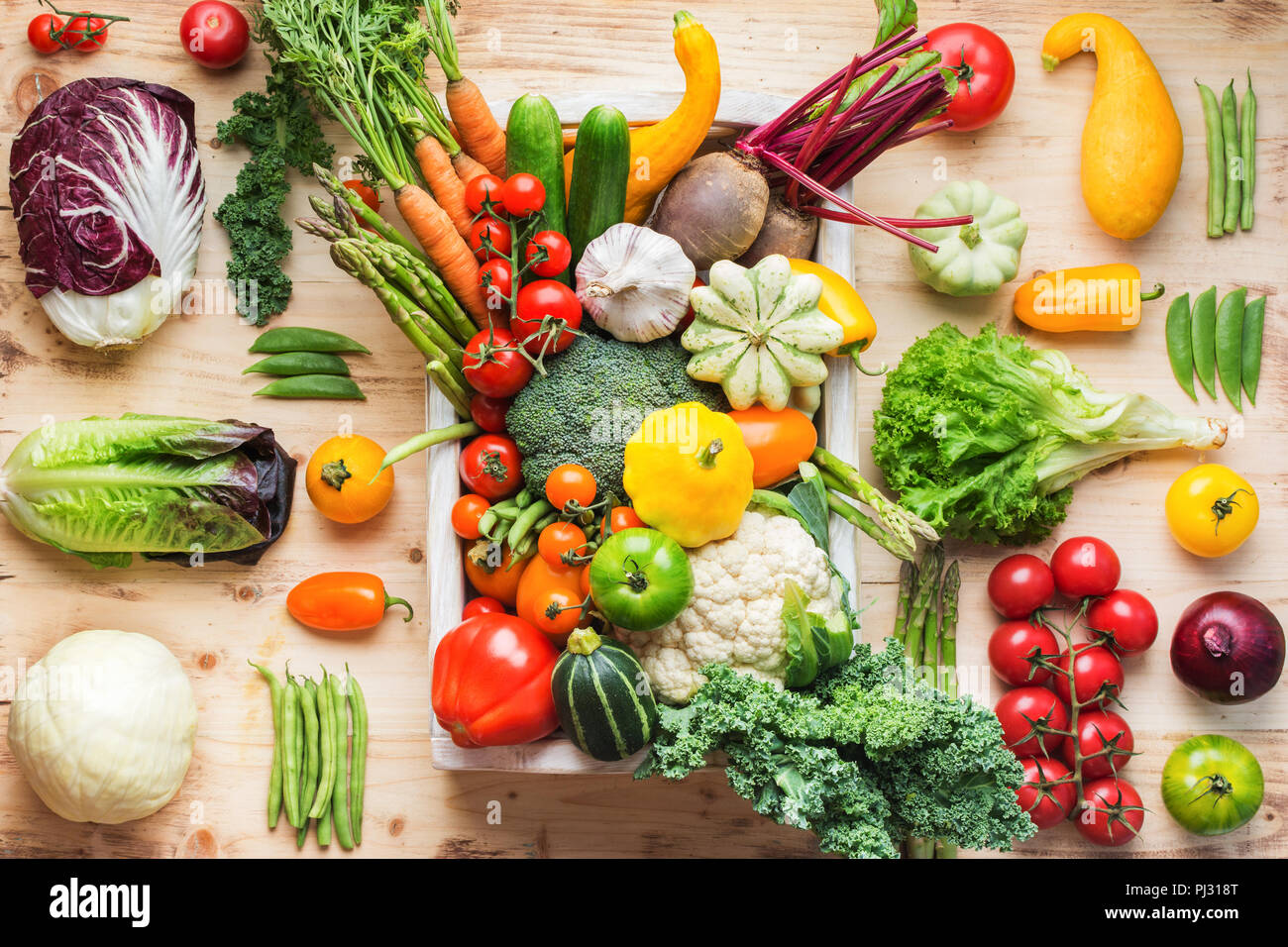 Assortment of fresh colorful organic vegetables in white tray on wooden ...