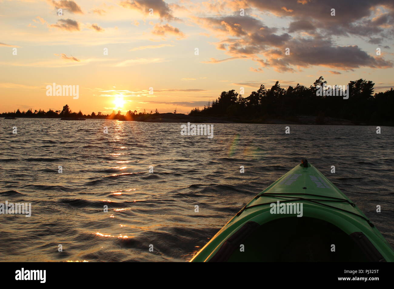 Sunset on Georgian Bay at Parry Sound view from kayak with ripples in the water Stock Photo