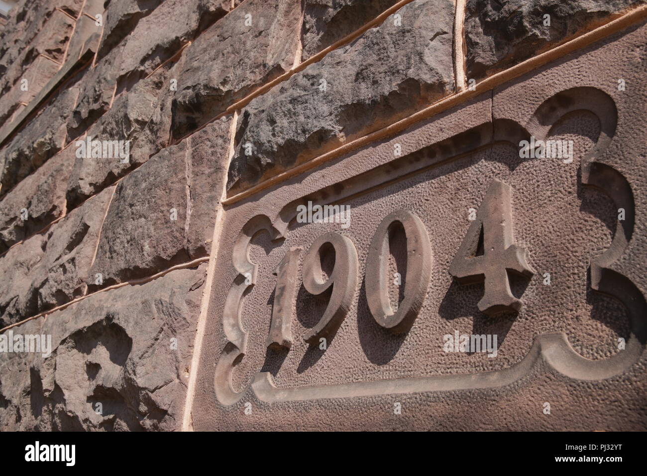 stone facade with date on old building 1904 Stock Photo
