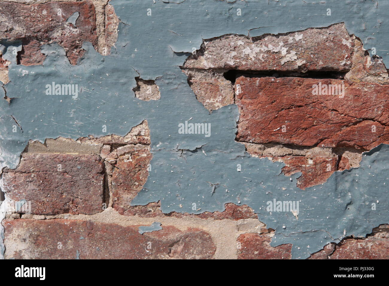 old paint peeling from brick wall Stock Photo