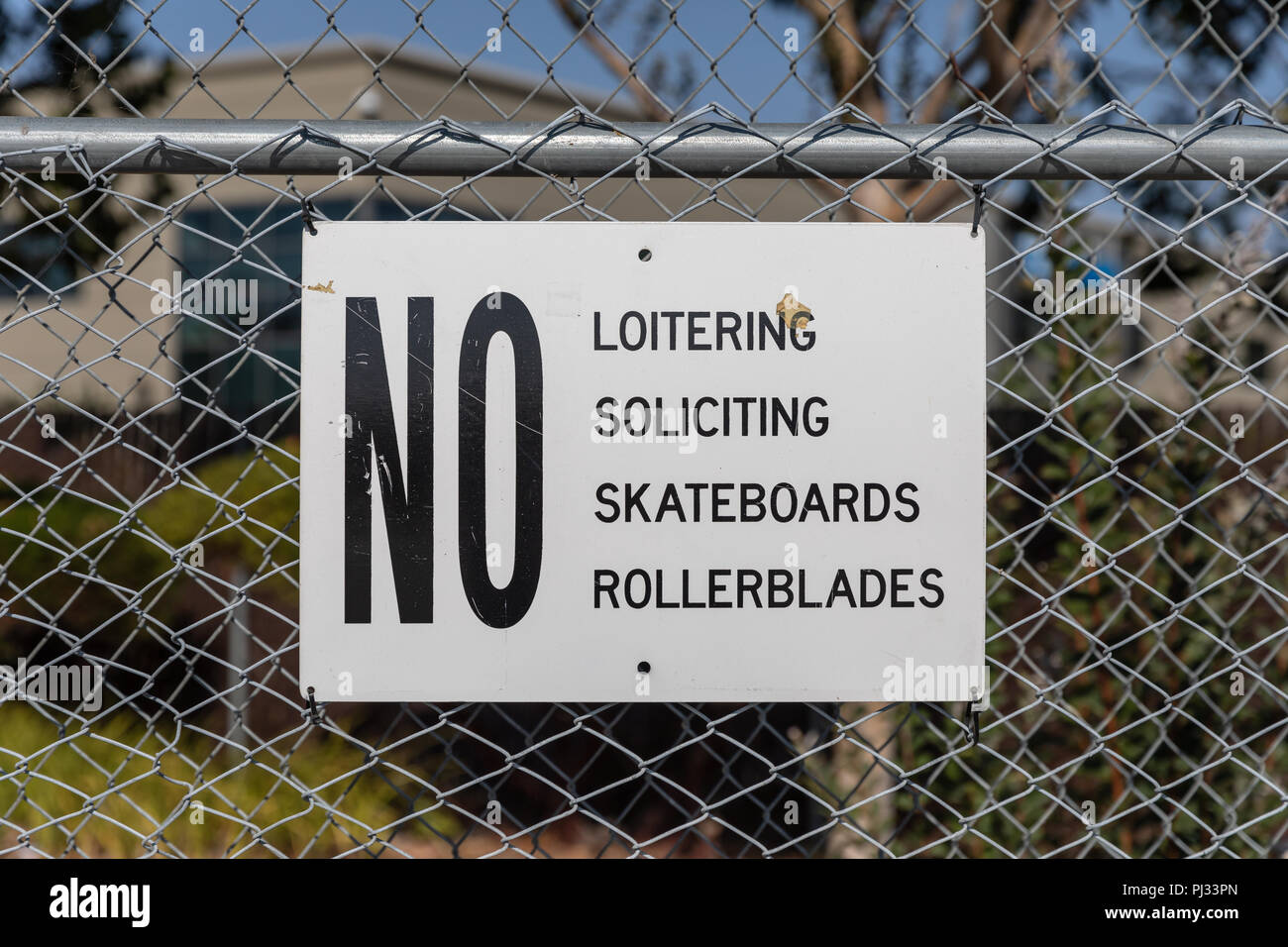 No Loitering, Soliciting, Skateboards, Rollerblades, sign on fence; California, USA Stock Photo