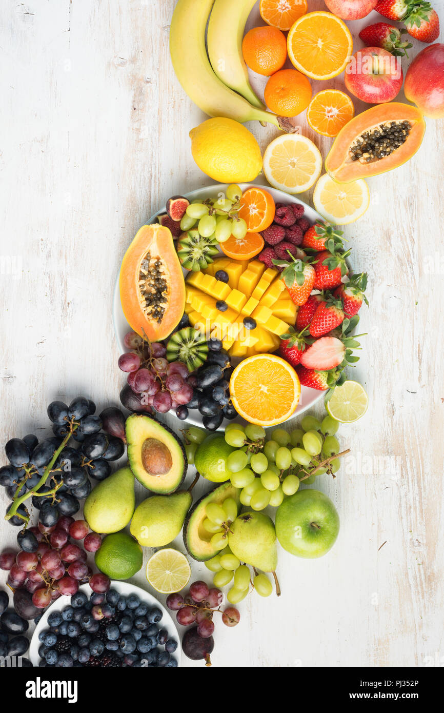 Healthy eating background, assortment of fruits and vegetables in rainbow colours on the off white table arranged diagonally, copy space, vertical, top view, selective focus Stock Photo